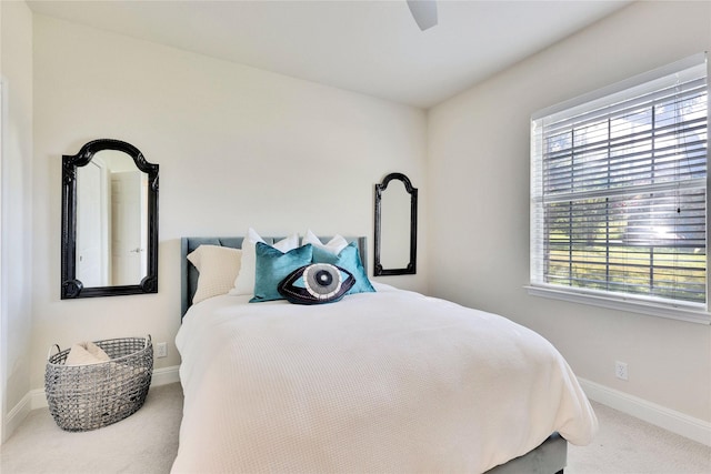 carpeted bedroom with ceiling fan and baseboards