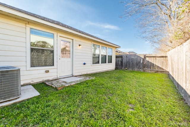 rear view of property featuring cooling unit, a fenced backyard, and a yard