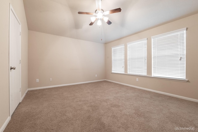 unfurnished room with lofted ceiling, carpet flooring, ceiling fan, and baseboards