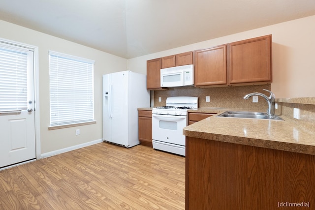 kitchen featuring white appliances, a sink, light countertops, light wood-type flooring, and backsplash