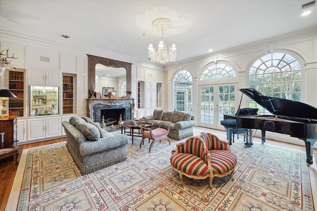 living area with french doors, a premium fireplace, visible vents, and crown molding