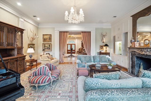 living area featuring visible vents, a fireplace, a chandelier, and ornamental molding