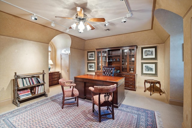 office space featuring visible vents, arched walkways, ceiling fan, rail lighting, and carpet flooring