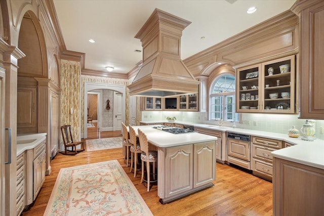 kitchen with arched walkways, stainless steel gas cooktop, crown molding, light countertops, and glass insert cabinets