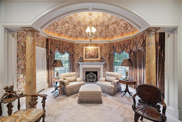 sitting room with an inviting chandelier, decorative columns, a premium fireplace, and a wealth of natural light