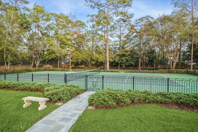 exterior space with a tennis court, fence, and a lawn