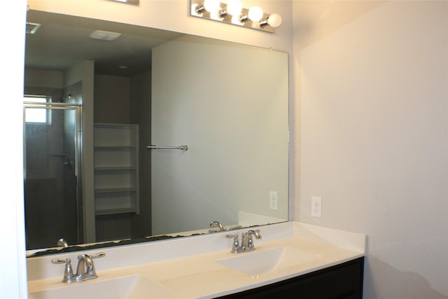 bathroom with double vanity, a sink, and a shower stall