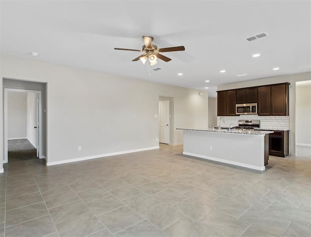 kitchen with visible vents, decorative backsplash, a ceiling fan, open floor plan, and stainless steel appliances