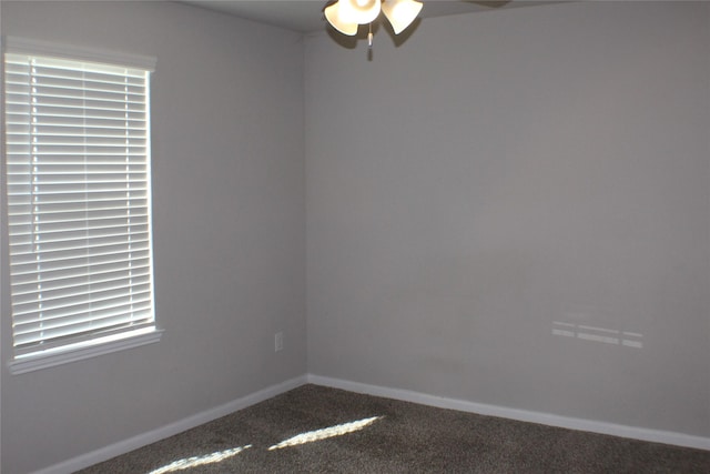 empty room with carpet flooring, a ceiling fan, and baseboards