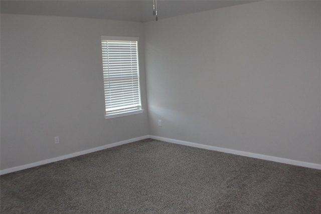 carpeted spare room featuring baseboards