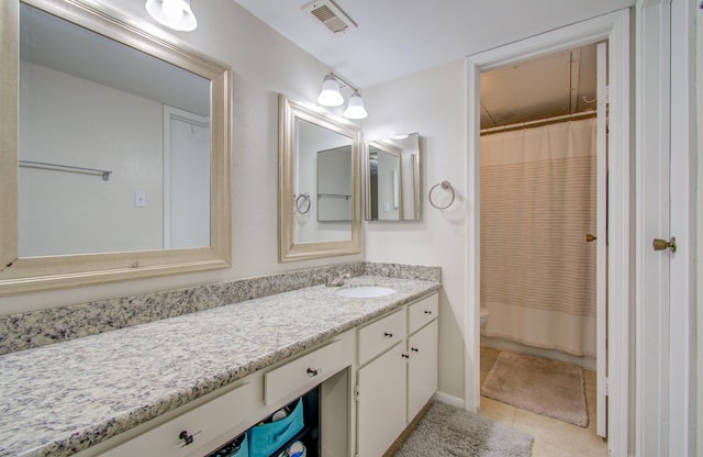 bathroom with curtained shower, visible vents, toilet, vanity, and tile patterned floors