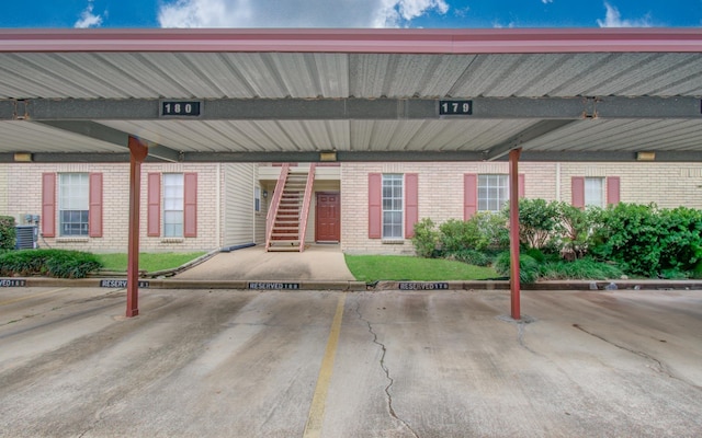 entrance to property featuring brick siding and covered parking