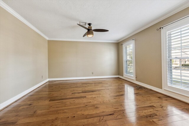 unfurnished room featuring baseboards, hardwood / wood-style floors, a ceiling fan, and ornamental molding