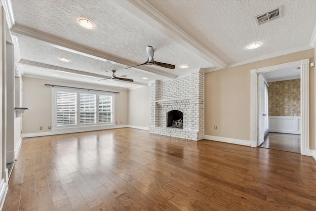 unfurnished living room with wood finished floors, a ceiling fan, visible vents, ornamental molding, and beamed ceiling