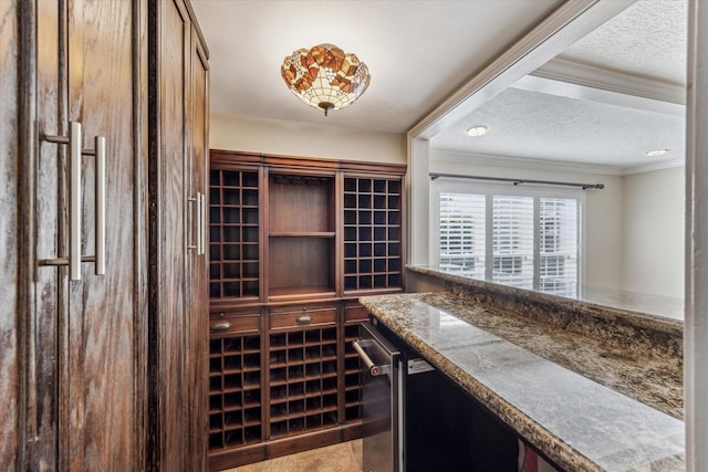 wine room with a textured ceiling and crown molding