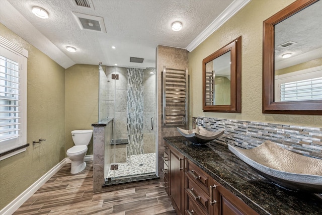 bathroom featuring toilet, wood finished floors, a shower stall, and a textured wall