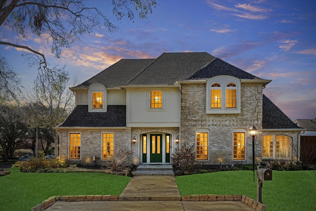 722 Crossroads Dr, Houston, TX 77079 - french country home with stucco siding, a front yard, and a shingled roof