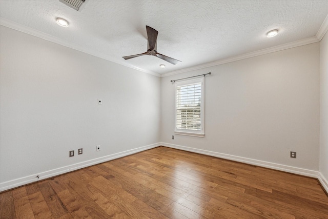 spare room featuring visible vents, crown molding, baseboards, ceiling fan, and hardwood / wood-style floors