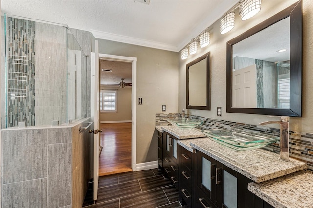 full bathroom with baseboards, wood tiled floor, a tile shower, ceiling fan, and ornamental molding