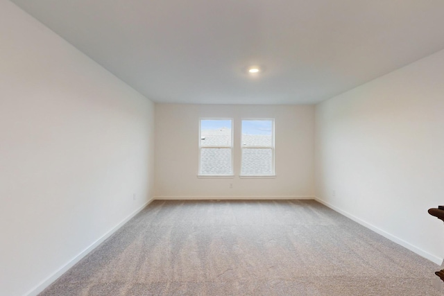 spare room featuring carpet floors and baseboards