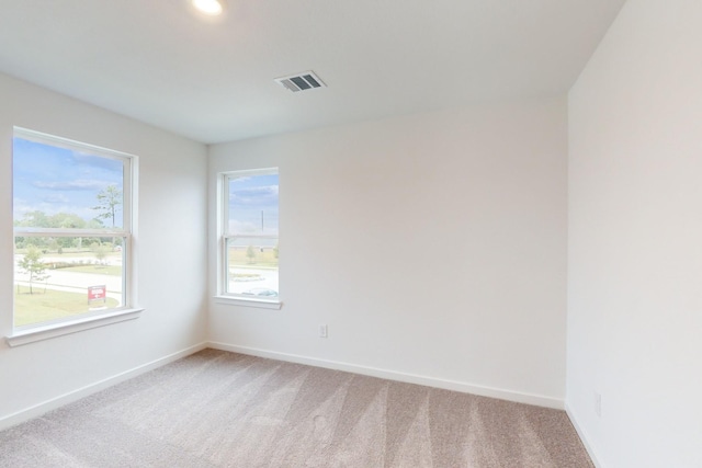 unfurnished room featuring light carpet, baseboards, and visible vents