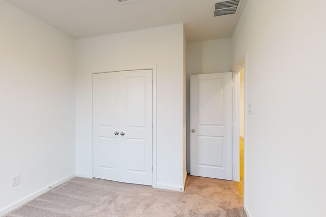 unfurnished bedroom featuring a closet, carpet flooring, visible vents, and baseboards