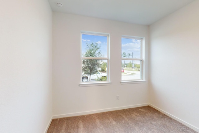 spare room with carpet and baseboards