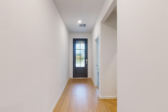 entryway with light wood-style flooring, visible vents, and baseboards