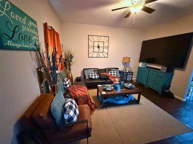 living room with ceiling fan, baseboards, and dark wood finished floors