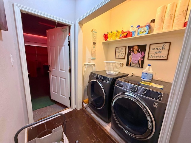 clothes washing area featuring laundry area, washer and clothes dryer, and wood finished floors