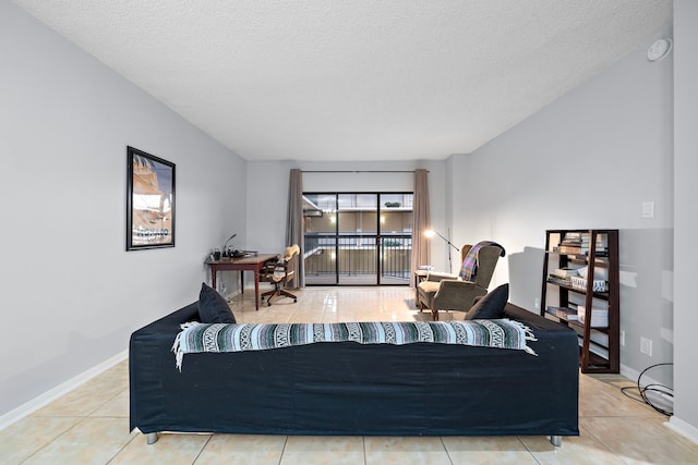 living room featuring tile patterned flooring, baseboards, and a textured ceiling