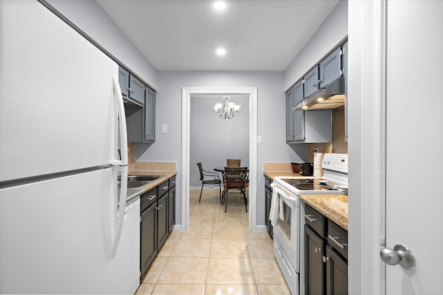 kitchen featuring light tile patterned floors, light countertops, a chandelier, white appliances, and under cabinet range hood