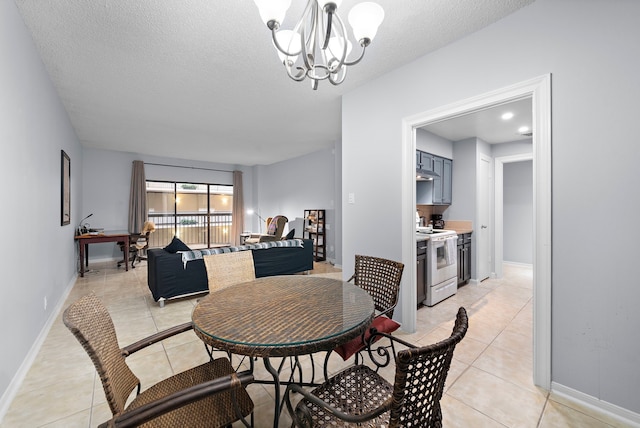 dining area featuring a chandelier, light tile patterned floors, a textured ceiling, and baseboards