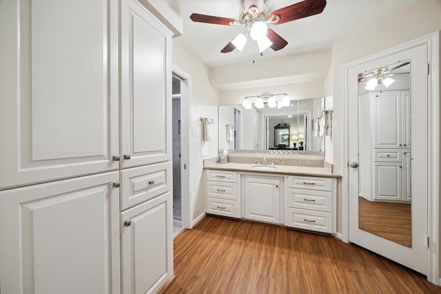 bathroom with ceiling fan, wood finished floors, and vanity