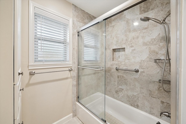 bathroom with enclosed tub / shower combo and baseboards