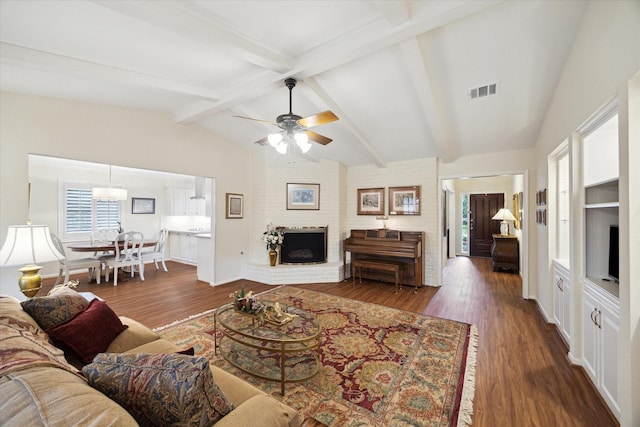 living room featuring visible vents, lofted ceiling with beams, a ceiling fan, a brick fireplace, and wood finished floors