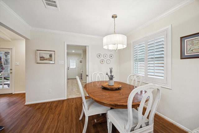 dining space featuring crown molding, visible vents, baseboards, and wood finished floors