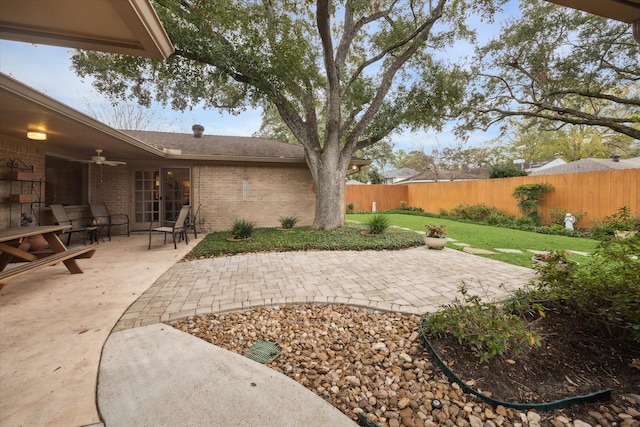 view of yard featuring a patio area, fence, and a ceiling fan