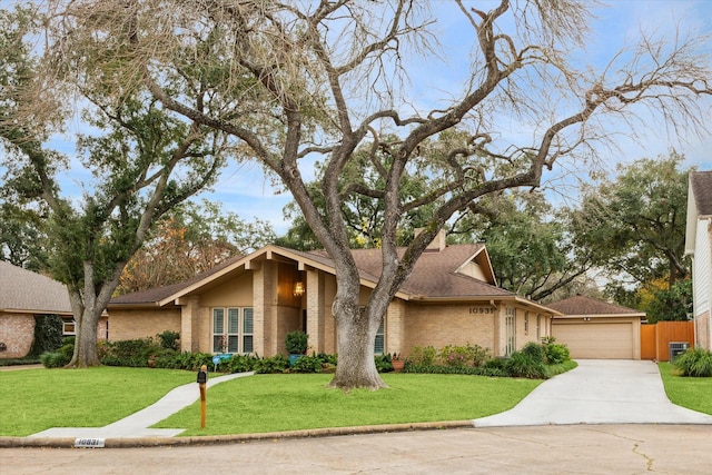 mid-century modern home featuring a garage, brick siding, roof with shingles, and a front yard