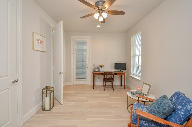 office space with light wood-style floors, baseboards, and a ceiling fan