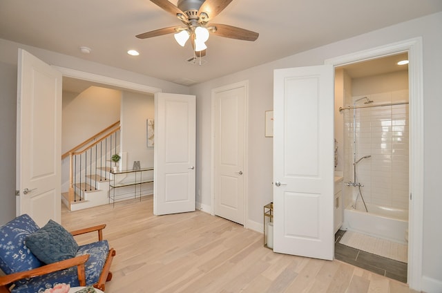 sitting room with ceiling fan, light wood-style flooring, recessed lighting, baseboards, and stairs