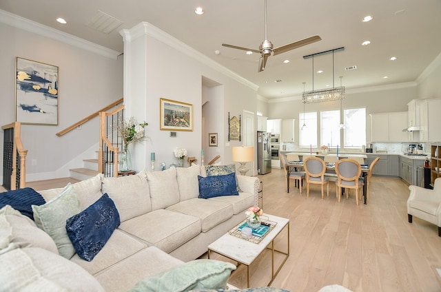 living room featuring light wood-type flooring, crown molding, recessed lighting, and stairs