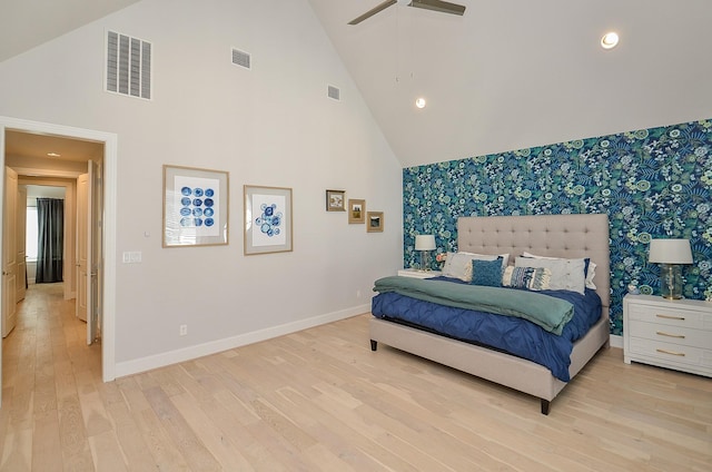 bedroom featuring baseboards, an accent wall, visible vents, and wallpapered walls