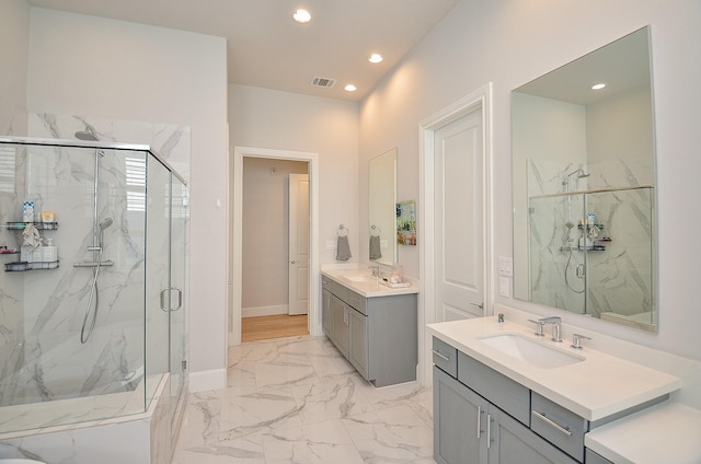 full bath featuring marble finish floor, visible vents, a sink, and a marble finish shower