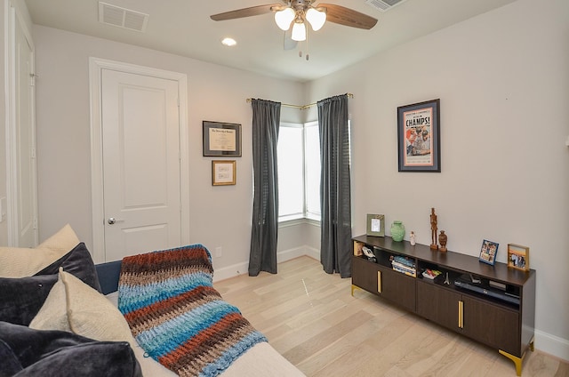 interior space with a ceiling fan, baseboards, visible vents, and light wood finished floors