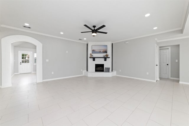 unfurnished living room with arched walkways, a fireplace, visible vents, a ceiling fan, and baseboards