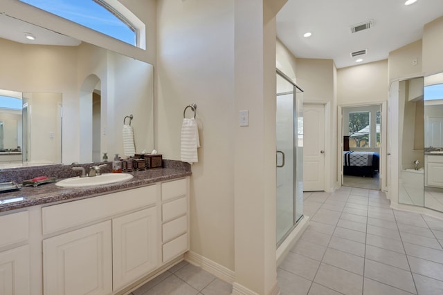 ensuite bathroom with ensuite bath, plenty of natural light, tile patterned flooring, and visible vents