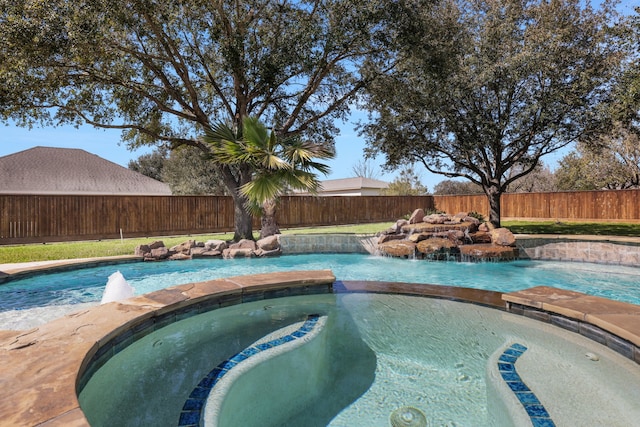 view of pool with a pool with connected hot tub and a fenced backyard