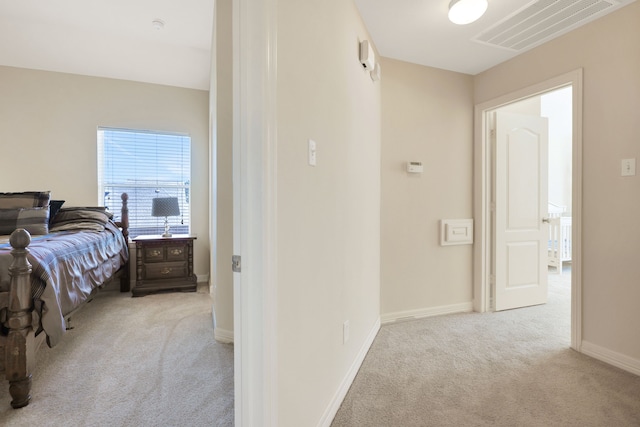 hallway featuring carpet, visible vents, and baseboards