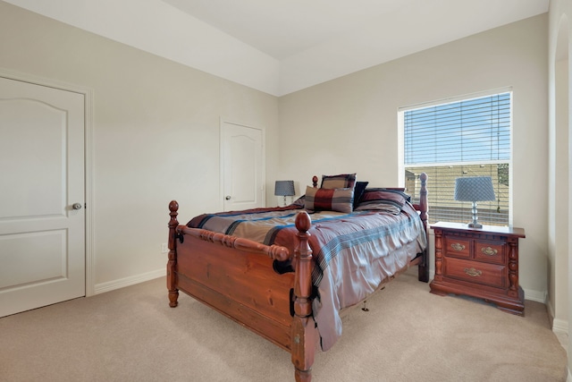 bedroom with light carpet and baseboards